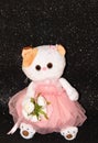 Toy white cat on a black background in a pink dress Royalty Free Stock Photo