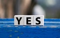 3 Toy Wood Blocks With Letters YES On a Wooden Table With Light Grey Background Royalty Free Stock Photo