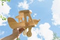 Toy airplane in hand and blue cloudy sky as background. Royalty Free Stock Photo