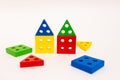 Toy wooden blocks, multicolor building construction bricks looking like house over white background. Early education