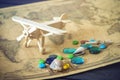 Toy wooden plane on a world map with colored stones and shells from the sea in a retro style. Royalty Free Stock Photo