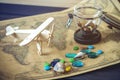 Toy wooden plane on a world map with colored stones and shells from the sea in a retro style. Royalty Free Stock Photo