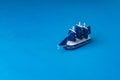 A toy wooden sailboat on a dark blue background imitating the sea Royalty Free Stock Photo