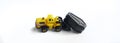 Toy yellow forklift with a coffin in a bucket on a white background. Concept of the exhumation of the coffin and forensic