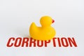 Toy yellow rubber duck on word corruption. Opposition symbol and political struggle. Minimalistic concept Royalty Free Stock Photo