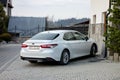 Toyota Camry Hybrid white sedan parked in front of the hotel resort in High Tatras in Poland