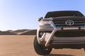 Toyota Fortuner standing in the middle of the Namib desert on a sunny day.