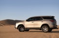 Toyota Fortuner standing in the middle of the Namib desert on a sunny day.