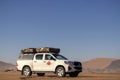 Toyota Hilux stands in the golden sands of the Namib desert. Africa