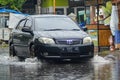 A Toyota Vios car that crashed through floodwater during heavy rain on a residential street