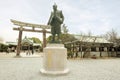 Toyotomi Hideyoshi statue in the Osaka castle park area and wooden torii gate Royalty Free Stock Photo