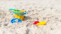 Toys at the beach - plastic yellow bucket, rake, spatula, molds on a sandy seaside beach Royalty Free Stock Photo