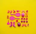 Toys for girls. Flat lay Pink toys on a yellow background. Royalty Free Stock Photo