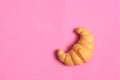 Toys for kids in food theme. One Croissant on pink background. Food and toy concept. Object made from plastic