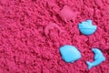 Toys on pink kinetic sand, flat lay