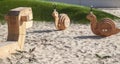 toys of rocking chair in form of snails on modern playground with covering from sand