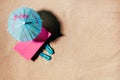 Toys sunlounger with umbrella and beach sandals or thongs on a sandy beach, copy space, top view