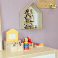 Toys on wooden desk with picture frame and shelves on wall