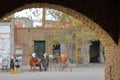 Locals traditionally dressed viewed from the medina through an arcade, and with buildings decorated with patterns of bricks