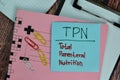 TPN - Total Parental Nutrition write on sticky notes isolated on Wooden Table Royalty Free Stock Photo