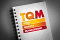 TQM - Total Quality Management acronym on notepad, business concept background Royalty Free Stock Photo