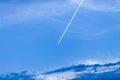 Trace of an airplane against blue sky. Plane with condensation trail in front of blue sky. Royalty Free Stock Photo