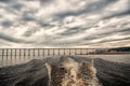Trace of speed boat on blue sea water in manaus, brazil. Seascape with bridge on horizon on cloudy sky. travelling and