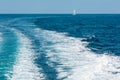 Trace on water surface in the sea and sailing vessel in far Royalty Free Stock Photo