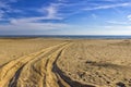 Traces of car tires on the sand of the sea beach. Royalty Free Stock Photo