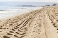 Traces of car tires on the sand of the sea beach at the water`s edge Royalty Free Stock Photo