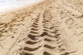 Traces of car tires on the sand of the sea beach at the water`s edge Royalty Free Stock Photo