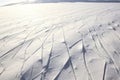 Traces in a geometric pattern on a snow-covered ground left by people or objects in a silent winter landscape.