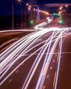 Traces of headlights from cars moving at night on the bridge, illuminated by lanterns. Abstract cityscape with highway at dusk Royalty Free Stock Photo