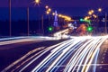 Traces of headlights from cars moving at night on the bridge, illuminated by lanterns. Abstract city landscape with highway Royalty Free Stock Photo