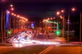 Traces of headlights from cars moving at night on the bridge, illuminated by lanterns. Abstract city landscape with highway Royalty Free Stock Photo