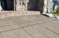 Traces on paving slabs from a shell hit. Part of the building destroyed by the shock wave and shrapnel.