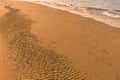 Traces on the sand and waves on shoreline