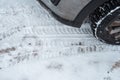 Traces of snow in the winter on the road. A dirty car with a wheel. Royalty Free Stock Photo