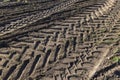 Traces of a tractor or other large machinery on the soil in the field Royalty Free Stock Photo