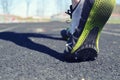 Track athlete image, of person walking on track before practice in the daylight. Shows rubber under feet and hurdles in the back. Royalty Free Stock Photo