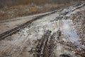 Track from car tire in dirt road in spring. Traces of stuck vehicles in liquid mud. Danger to driving Royalty Free Stock Photo