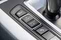 Track control buttons near automatic gear stick of a modern car, car interior details.