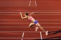 Track-and-field athletics. Young Caucasian woman, professional athlete, runner training at public stadium, sport court