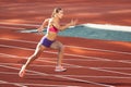 Track-and-field athletics. Young Caucasian woman, professional athlete, runner training at public stadium, sport court