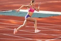 Track-and-field athletics. Young Caucasian woman, professional athlete, runner training at public stadium, sport court