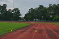 Track and fields with 2 yellow cone on track with artificial grass inside a stadium