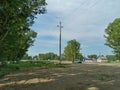 The track passing through the village, surrounded by trees, poplars. Rural area in the CIS countries Royalty Free Stock Photo