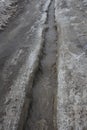 The track on the road is filled with dirty water the snow melts in the stream Royalty Free Stock Photo
