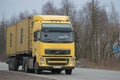 Track of VOLVO FH 13 440 with the semi-trailer container carrier on the highway in the gloomy March day