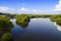 Track a wide river with high green trees on the banks against the background of the blue sky Royalty Free Stock Photo